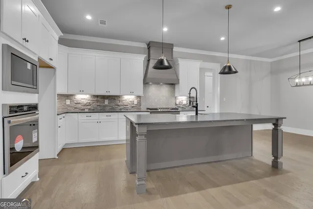 a kitchen with granite countertop a sink stainless steel appliances and cabinets