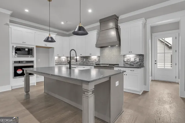 a view of empty room with wooden floor and chandelier