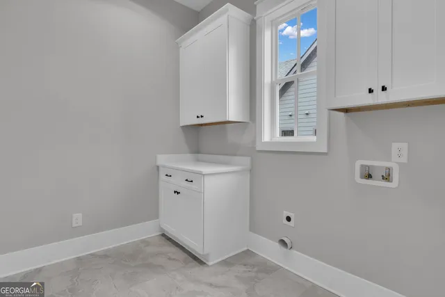 an empty room with chandelier fan and windows