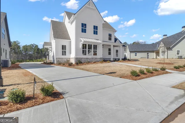 a view of a white house with a yard next to a road