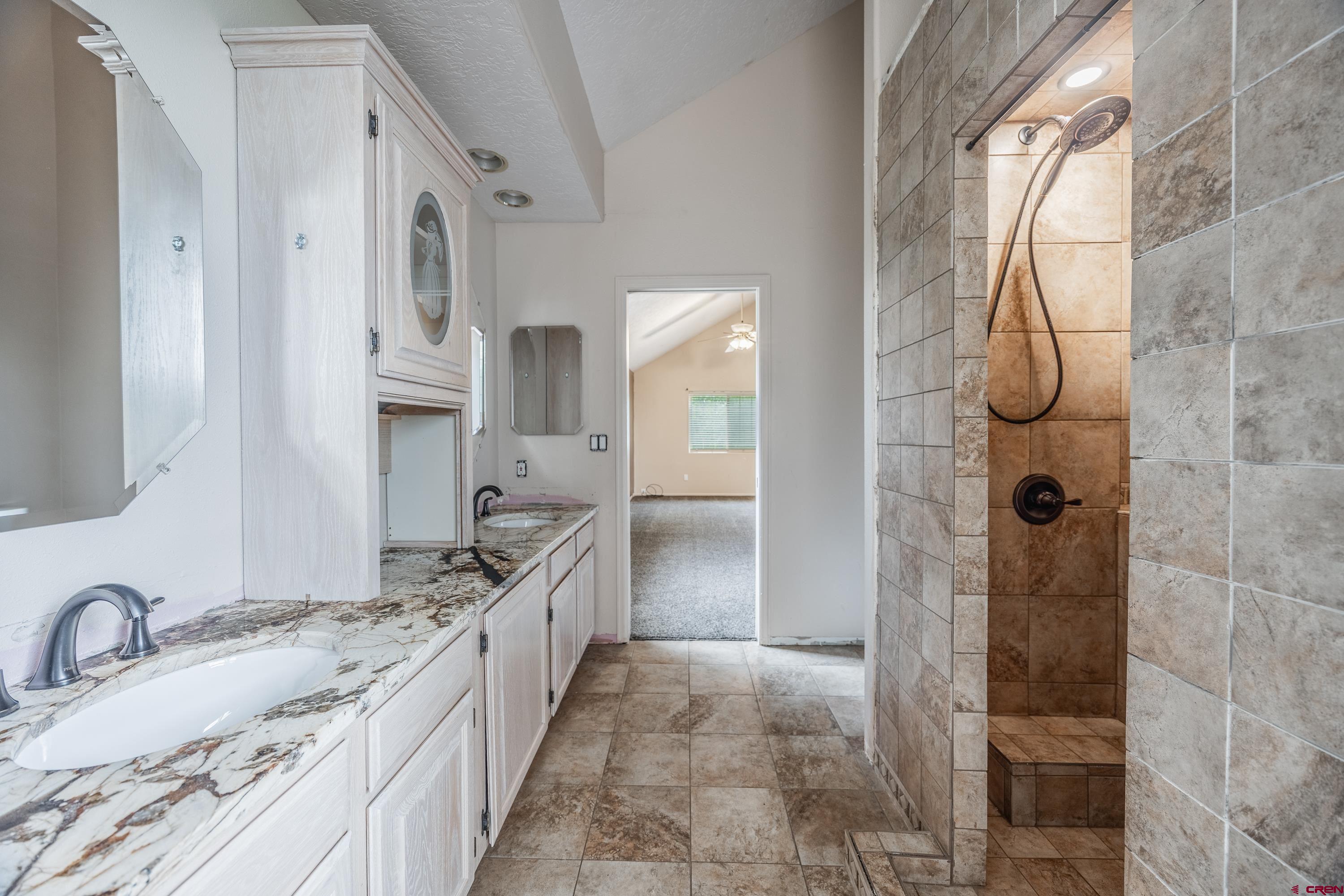 17377 Breeze Road Delta, CO 81416 - Photo 5 of 45 a bathroom with a granite countertop sink a mirror and a shower