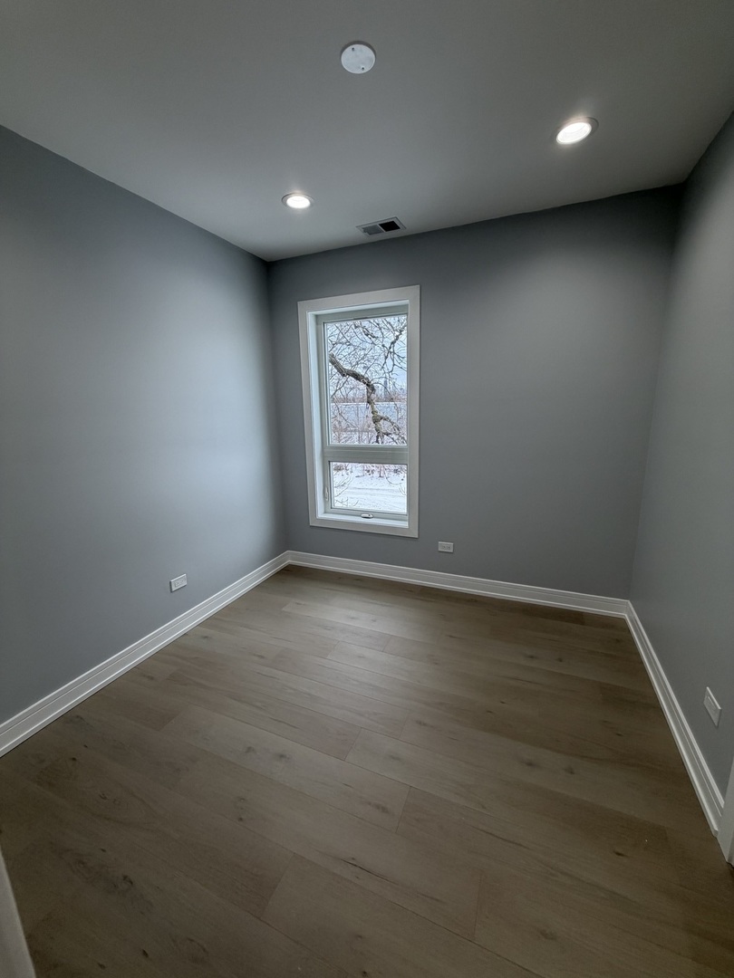 2622 West Adams Street, Unit 2 Chicago, IL 60612 - Photo 17 of 26 an empty room with wooden floor and windows