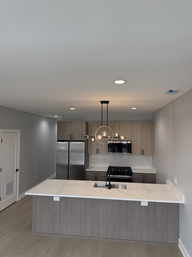 2622 West Adams Street, Unit 2 Chicago, IL 60612 - Photo 5 of 26 a large room with a large window and kitchen island