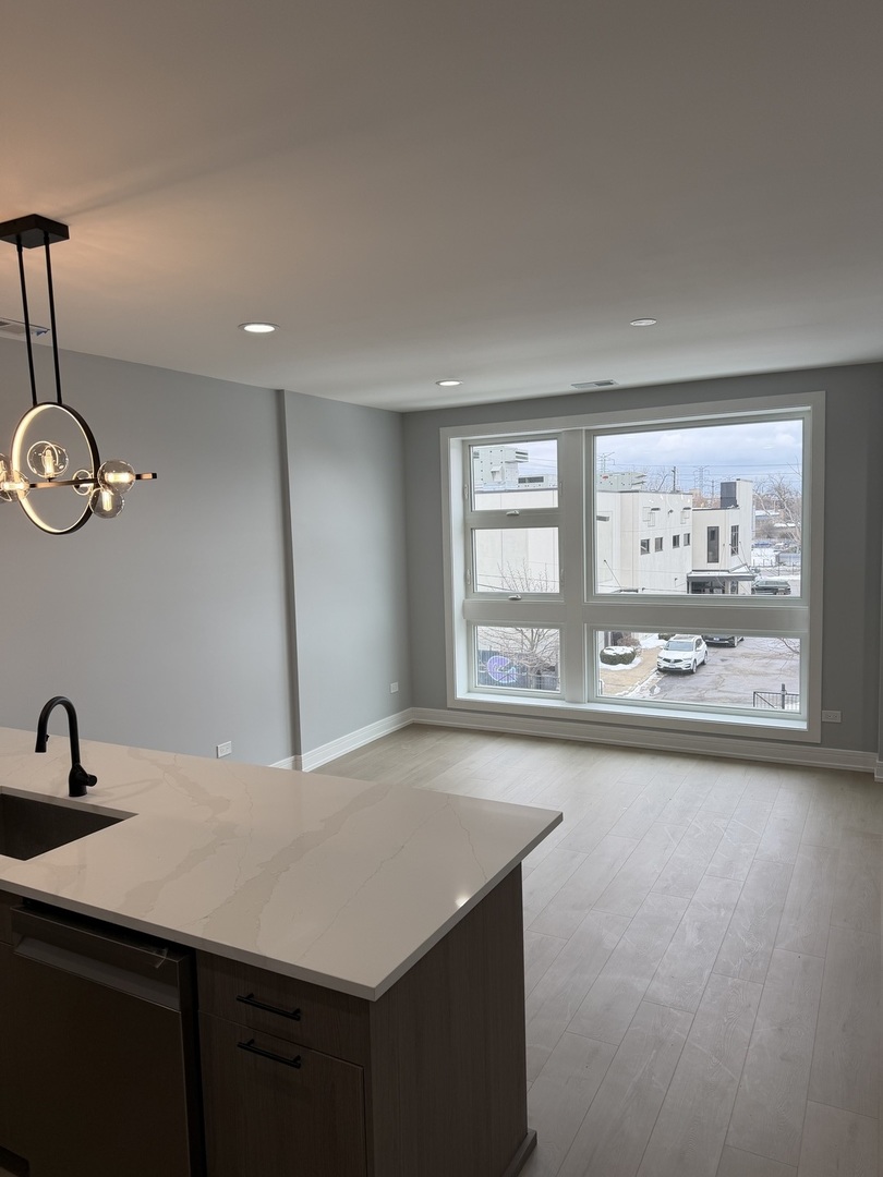 2622 West Adams Street, Unit 2 Chicago, IL 60612 - Photo 7 of 26 a view of a kitchen with a sink dishwasher and wooden floor