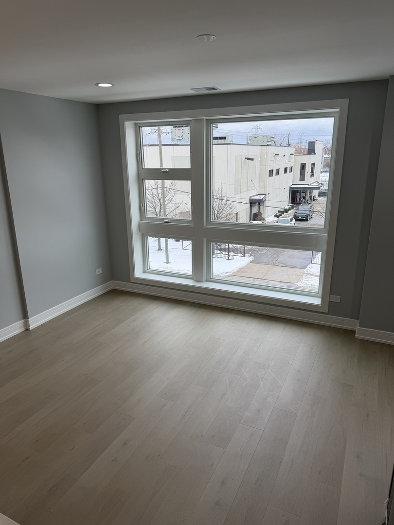 2622 West Adams Street, Unit 2 Chicago, IL 60612 - Photo 9 of 26 an empty room with wooden floor and windows