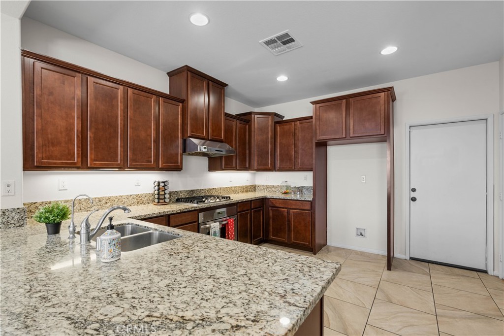 8039 City View Place Rancho Cucamonga, CA 91730 - Photo 6 of 39 a kitchen with stainless steel appliances granite countertop a sink stove and refrigerator