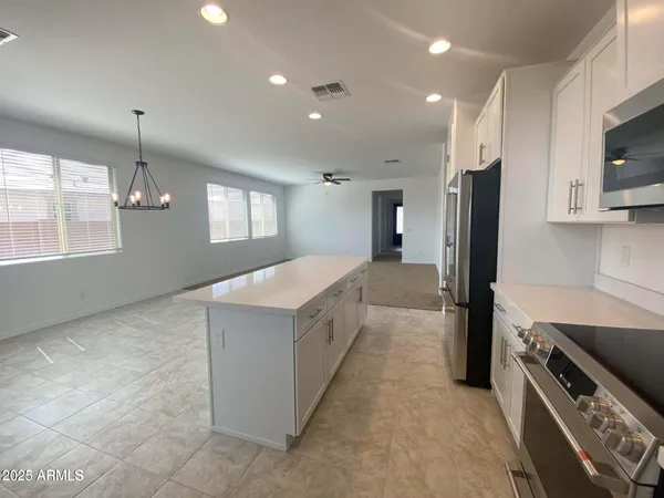 a large kitchen with a large counter top stainless steel appliances and cabinets