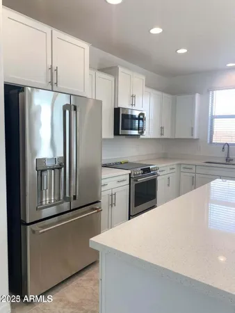 a kitchen with stainless steel appliances a refrigerator sink and microwave