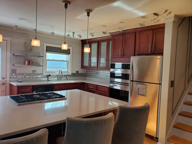a kitchen with a refrigerator a sink and wooden floor