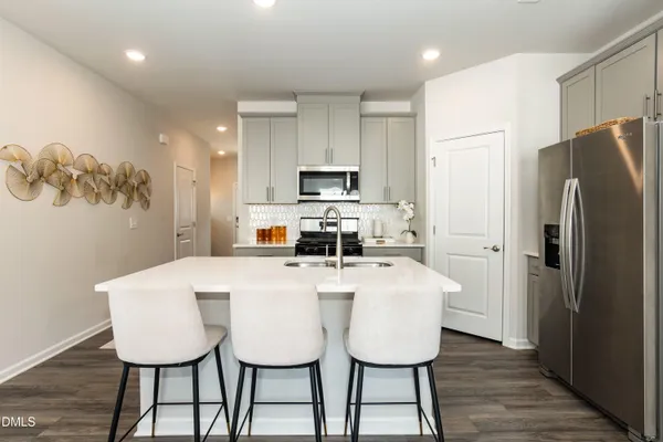 a view of kitchen with stainless steel appliances granite countertop a dining table and chairs