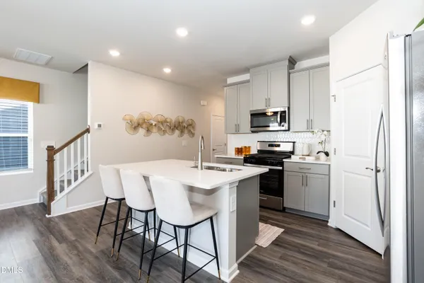 a kitchen with a table chairs refrigerator and microwave