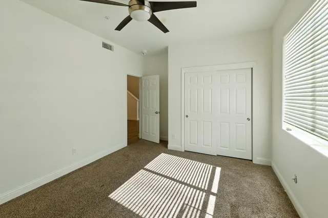 an empty room with closet and windows