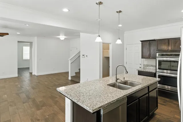 a kitchen with a sink a counter space appliances and cabinets