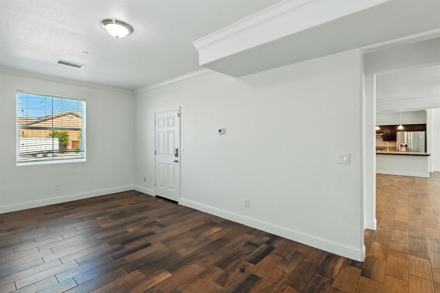 1732 Cleveland Street Selma, CA 93662 - Photo 6 of 24 a view of an empty room with wooden floor and a window