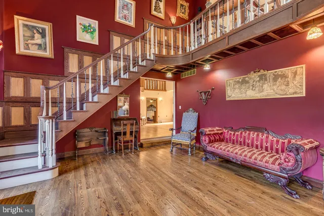 a bedroom with a bed a flat screen tv and a large window with wooden floor