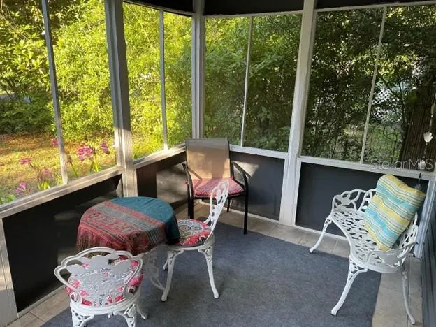 a dining room with furniture and a floor to ceiling window
