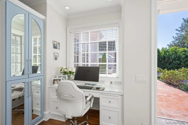 a view of a workspace with furniture and a window
