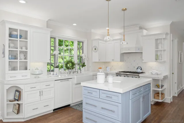 a kitchen with a stove a sink a center island and wooden floor