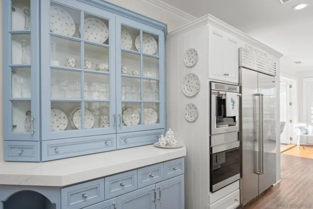 a kitchen with a refrigerator and a white cabinets