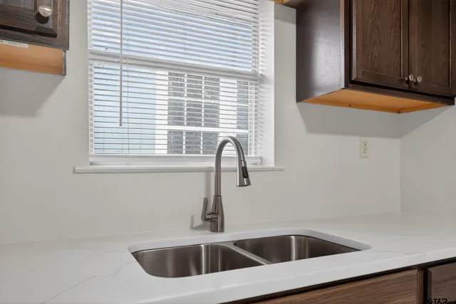 a view of a livingroom with a ceiling fan & windows