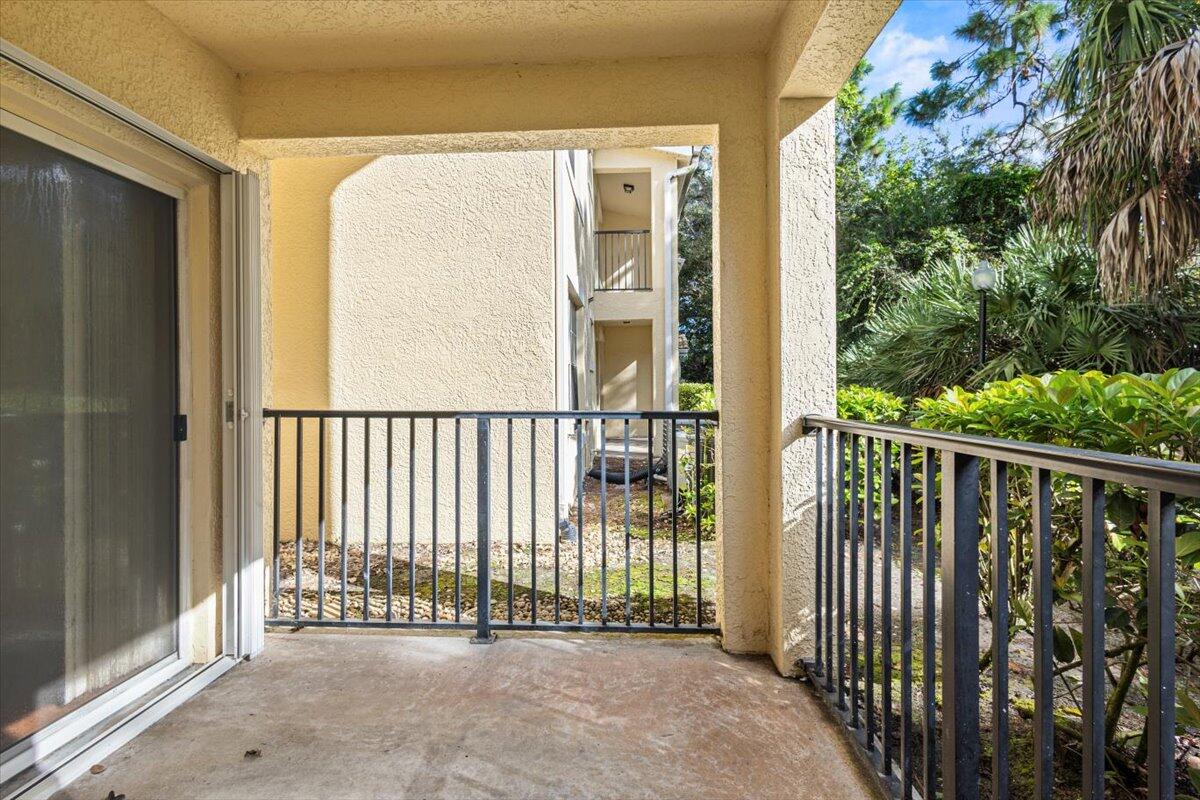 110 Southwest Peacock Boulevard, Unit 6101 Port St. Lucie, FL 34986 - Photo 27 of 70 a view of a balcony with a floor to ceiling window and wooden fence