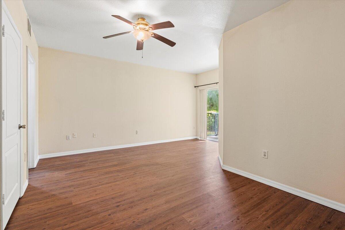 110 Southwest Peacock Boulevard, Unit 6101 Port St. Lucie, FL 34986 - Photo 32 of 70 an empty room with wooden floor and a ceiling fan