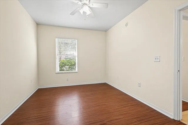 a living room with furniture a wooden floor and next to a window