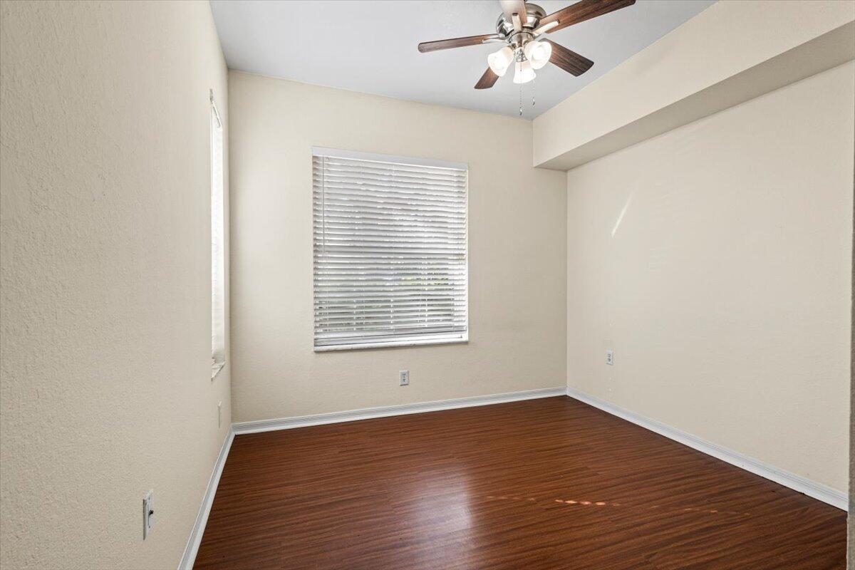 110 Southwest Peacock Boulevard, Unit 6101 Port St. Lucie, FL 34986 - Photo 39 of 70 a view of an empty room with wooden floor and a window