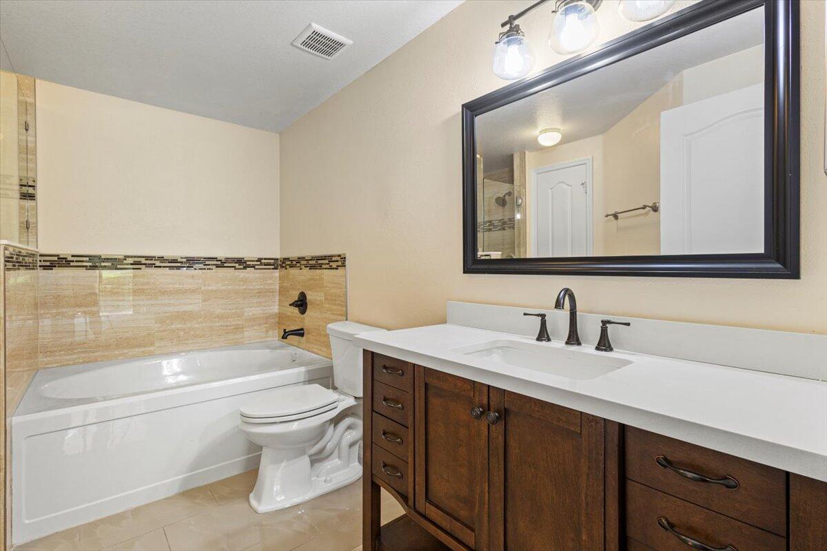 110 Southwest Peacock Boulevard, Unit 6101 Port St. Lucie, FL 34986 - Photo 9 of 70 a bathroom with a toilet a sink a tub and mirror