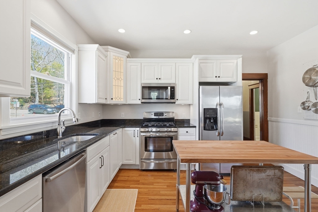 42 Lagrange Street, Unit U1 Boston, MA 02132 - Photo 25 of 42 a kitchen with stainless steel appliances granite countertop a refrigerator a sink dishwasher a stove and white countertops with wooden floor