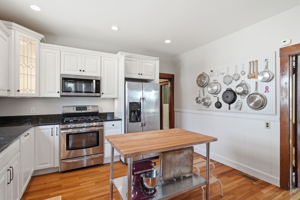 42 Lagrange Street, Unit U1 Boston, MA 02132 - Photo 26 of 42 a kitchen with stainless steel appliances a stove a refrigerator and a fireplace
