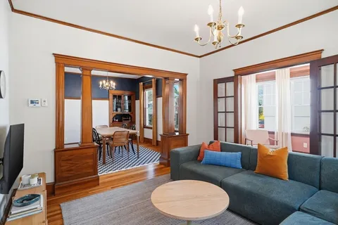 a living room with furniture a dining table and a large window