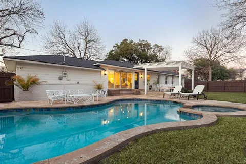 a view of a house with pool and a yard