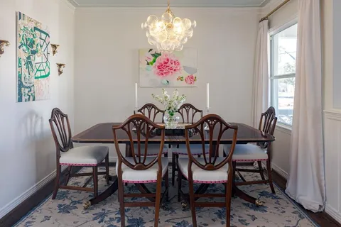 a view of a dining room with furniture a chandelier and wooden floor
