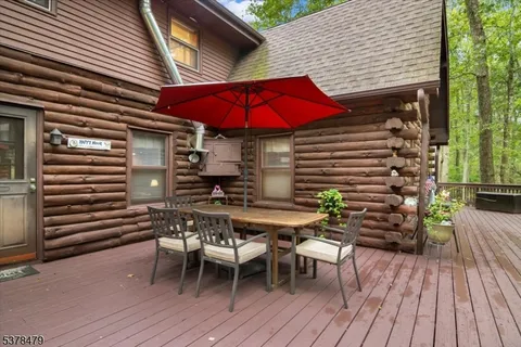 a patio with wooden floor a yard a table and chairs