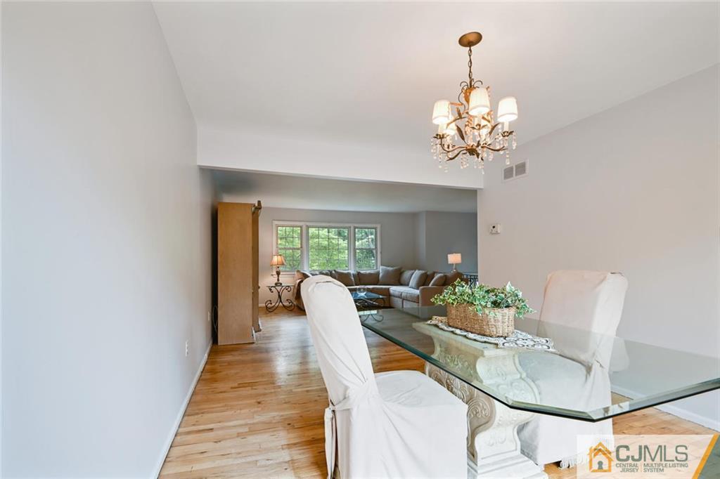 4 Revock Road East Brunswick, NJ 08816 - Photo 12 of 28 a living room with dining table furniture and a chandelier