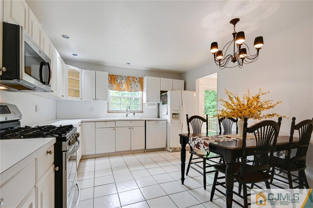 4 Revock Road East Brunswick, NJ 08816 - Photo 15 of 28 a kitchen with granite countertop a table chairs stove and microwave