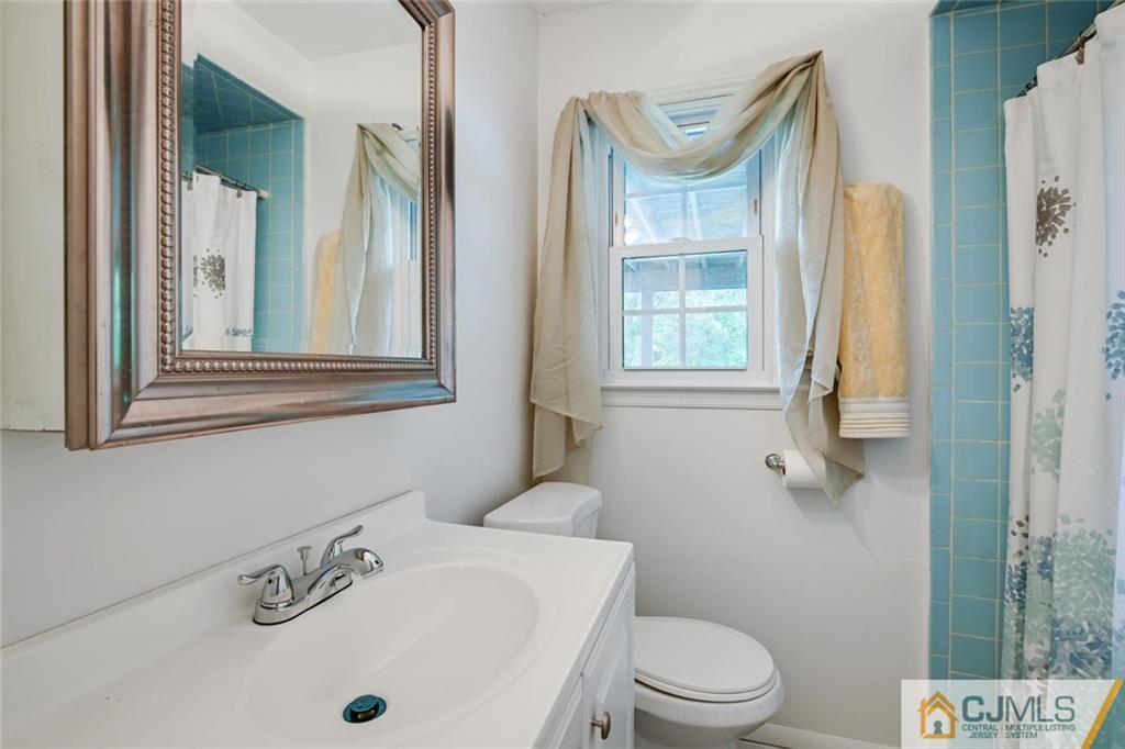4 Revock Road East Brunswick, NJ 08816 - Photo 25 of 28 a bathroom with a sink a toilet and a mirror