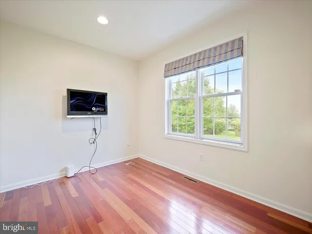 a view of a room with wooden floor and windows