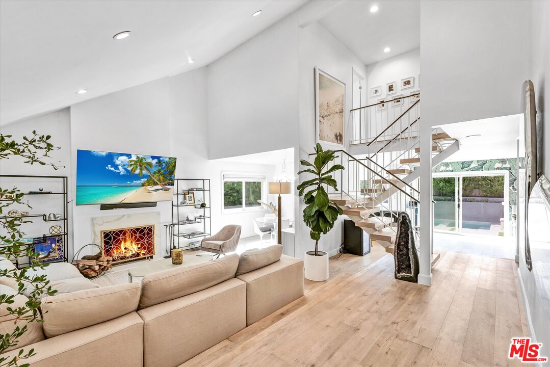 a living room with furniture fireplace and potted plants