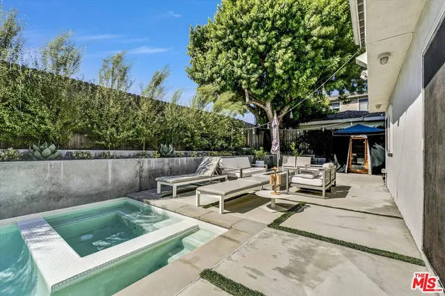 a view of a patio with couches table and chairs and potted plants