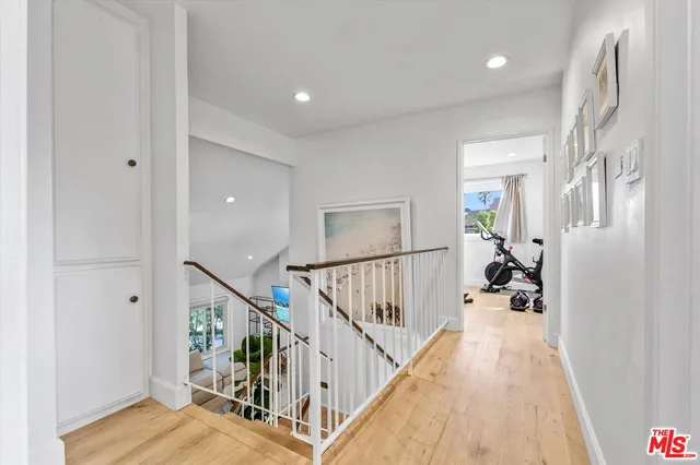 a view of a hallway with wooden floor and staircase