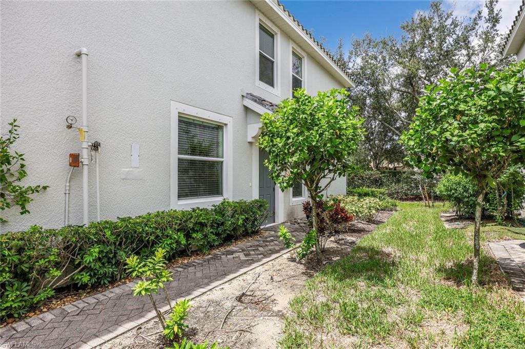 16162 Ravina Way, Unit 65 Naples, FL 34110 - Photo 21 of 22 a view of a house with a yard and plants