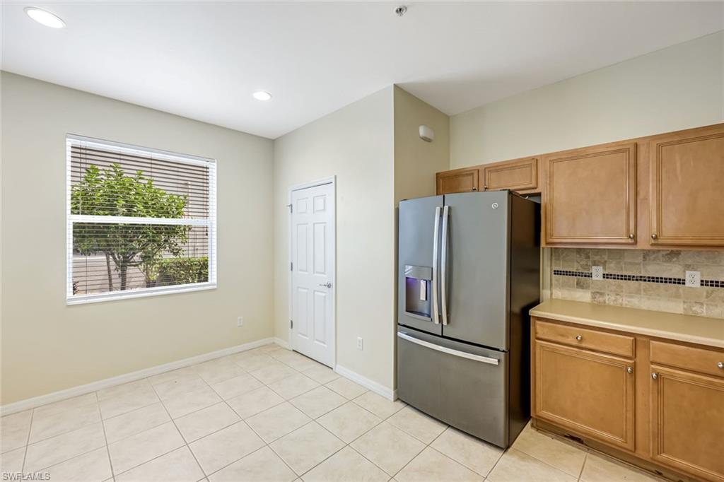 16162 Ravina Way, Unit 65 Naples, FL 34110 - Photo 9 of 22 a kitchen with stainless steel appliances a refrigerator sink and cabinets