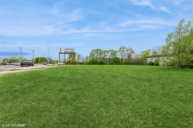 a view of a green field with houses in the background