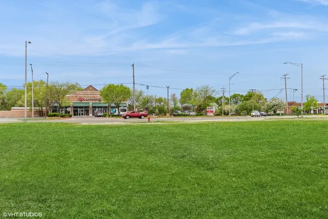 a view of yard with multi story residential apartment building in front of it