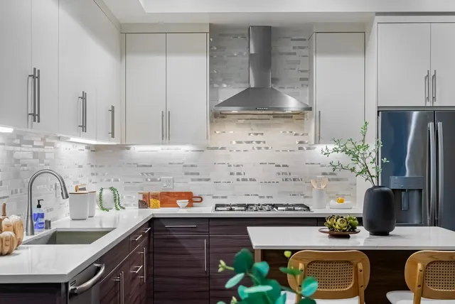 a kitchen with stainless steel appliances granite countertop a sink stove refrigerator and cabinets