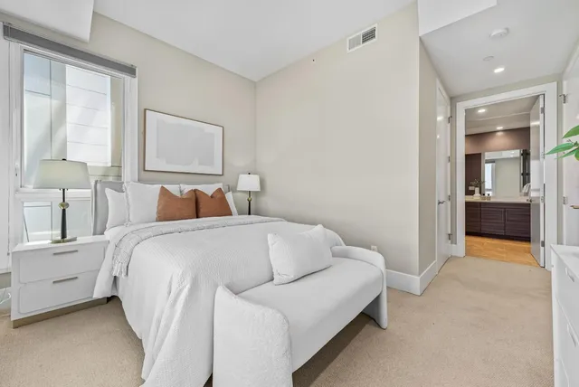 a bedroom with a bed and a large window