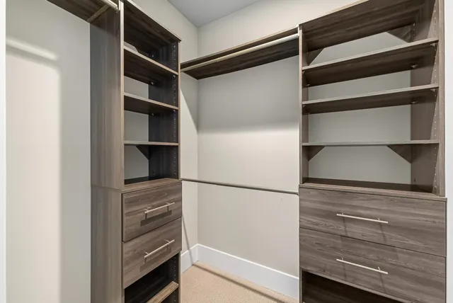 a view of walk in closet with empty racks