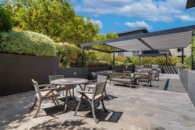 a view of a patio with a table and chairs under an umbrella